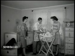 1946: ADOPTION: DRAMATIZATION: CU Cover of Baby Diary, opening, turning pages in book November to January. Social Worker checking up on baby, trial period. Couple w/ baby in nursery, powdering, brushing hair. Cocker Spaniel family dog sitting, looking Instructional Video