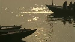 Rowboats cruise along the sun-dappled Ganges River. Stock Footage