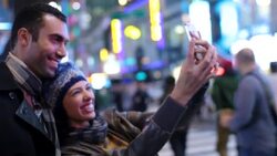 Young couple in love take photo together with smartphone in Times Square Stock Footage
