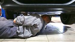Car mechanic working under a vehicle. Stock Footage