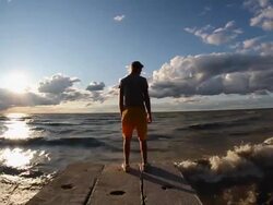 Portrait of a young man on a wall during sunset at the beach. - Model Released - HD Stock Footage