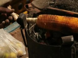 Street hawker roasting corn cob on a stove, Rishikesh, Uttarakhand, India Stock Footage