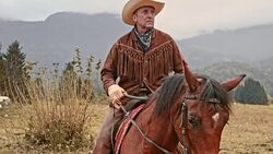 SLO MO Rancher riding his horse across a mountain Stock Footage