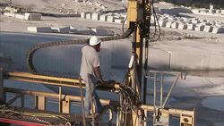 A worker adjusts machinery at a granite quarry. Stock Footage