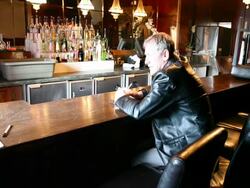 Broken Man at Bar as Barman Packs Stools Stock Footage