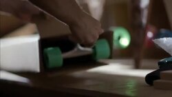 Skate shop worker packs longboard with bubble wrap in cardboard box for shipment Stock Footage