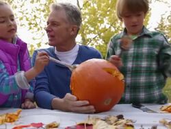 Grandfather and grandchildren carving pumpkin Stock Footage