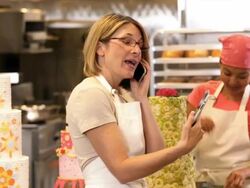 MS Baker in Commercial Kitchen Looking at Cake Photo on Tablet Computer While Talking on Cell Phone / Richmond, Virginia, USA Stock Footage