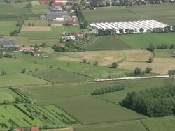 MS AERIAL ZI TS PAN TU View of Belgian Train passing through farm land / Flanders, Belgium Stock Footage