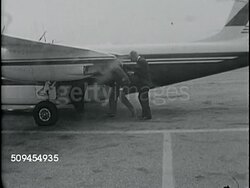 1963: PRIVATE AIRPLANE: Two businessmen walking w/ David Schwartz on tarmac to airplane. INT Airplane behind businessmen in pilot & co-pilot seats. David Schwartz in passenger's seat. Instructional Video