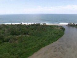 Aerial view of coastline of Tayrona National Natural Park [Parque Nacional Natural Tayrona], Sierra Nevada, Colombia from helicopter Stock Footage