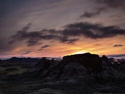 Sunset in Iceland during midnight sun out near Landmannalaugar with a lava dome in the foreground. Shot is wide. Stock Footage