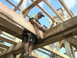 MS Carpenter nailing wood plank in place while framing an energy efficient post / Grass Lake, Michigan, USA    Stock Footage