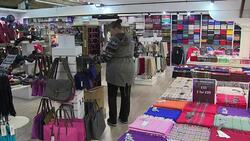 Customers browsing in a shop selling tartan and Scottish souvenirs News Clip