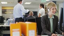 Businesswoman wearing headset using computer Stock Footage