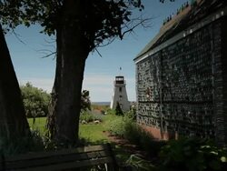 Lightouse in the background of a house made of glass  Stock Footage