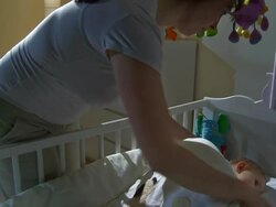 HD CRANE: Mother Putting Baby To Bed Stock Footage