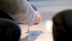 Creative young business people write on white-board table in large corporate office common area (detail) Stock Footage