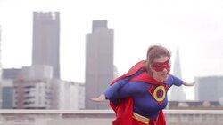 Superhero mother carrying daughter on city rooftop Stock Footage