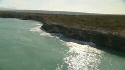 Waves crash against island cliffs. Stock Footage