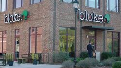Store owner walks up to small business storefront and unlocks door Stock Footage