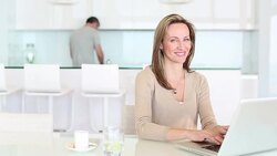Woman using laptop in kitchen Stock Footage