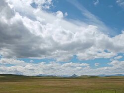 WS T/L View of Dramatic clouds on prairie with Rockie Mountains in back side and sun and shadows rolling across landscape / Augusta, Montana, United States Stock Footage