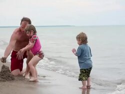 MS Little boy and little girl with father begin to build sand castle at waterbreak / Toronto, Ontario, Canada Stock Footage