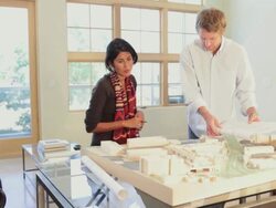 Architects in office with blueprints and design model Stock Footage