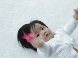 MS young baby in white holding origami crane laying on her back/Singapore  Stock Footage
