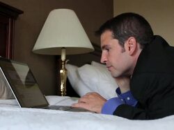 MS Man sleeping on bed working on laptop / Portland, ME, United States Stock Footage
