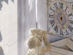CU Top of the Residenzbrunnen Fountain in Salzburg in Front of the Cathedral Clock Tower Stock Footage