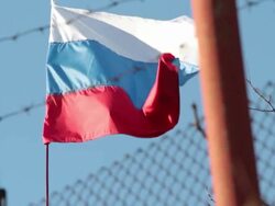 Russian flag flying in front of barbed wire Stock Footage