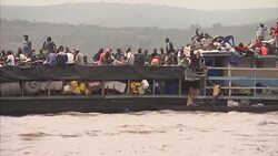 Wide shot of heavy loaded ferry sailing down Congo river Stock Footage