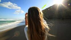 Young woman makes heart shape finger frame on beach Stock Footage