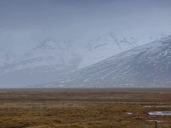 WS PAN View of road going towards snow mountain through small lake / Iceland Stock Footage