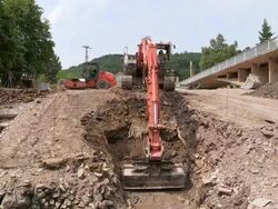 WS Shot of excavator engraving pit at bridge construction site preparing demolition of old bridge at Saar river/ Wiltingen, Rhineland Palatinate, Germany Stock Footage