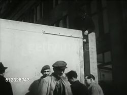 1953: BUILDING FOR CORONATION: VS Workers w/ large wooden gate open, closing (to block traffic at Trafalgar Square from procession route), checking w/ level. DECORATIONS: VS Artists, artisans painting crests, Royal Crown banners for display in streets. Instructional Video