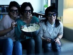 Girls on sofa watching Television with 3D glasses Stock Footage