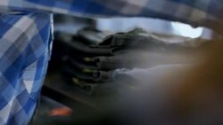 Young employee counts pants on shelf and types data on tablet in modern clothing store Stock Footage