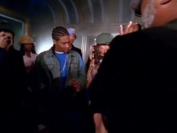 Slow motion medium shot crane shot female reporter interviewing hip hop stars / groupies in background Stock Footage