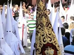 People watching the white hooded Nazarenos parade during the celebration of Semana Santa a Holy week in Malaga Spain, Europe Stock Footage