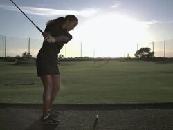 Woman golfer hitting an iron on a range in Slow Motion Stock Footage