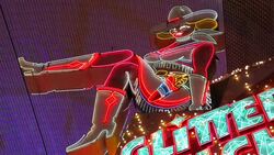 Bright neon lights shine on a sign shaped as a cowgirl located under the canopy of the Fremont Street Experience. Stock Footage