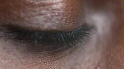 ECU African-American person opening brown eye Stock Footage