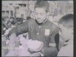 1942: JAPAN: MILITARY SCHOOL: XWS Group of cadets marching in formation in yard. WS Groups gathered on benches outdoors. VS Scooping rice, students eating at benches, pouring tea into cups, eating rice w/ chopsticks. Lunch, academy, WWII Instructional Video