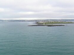 WS AERIAL View of lighthouse at island with Oskjuhlid city / Iceland Stock Footage