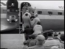 B/W 1961 REAR VIEW crowd of East German refugees boarding airplane / beginning of Berlin Wall Stock Footage