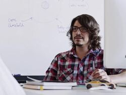 MS young businessman sitting in discussion at workstation in high tech office smiling Stock Footage