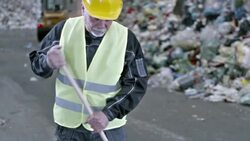 SLO MO worker sweeping the floor in a recycling facility Stock Footage